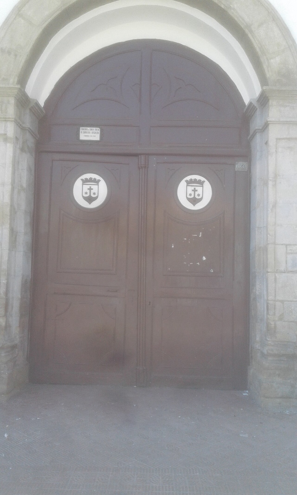 Portón de madera de dos hojas, con herrajes, en una casa de la calle España de Cochabamba